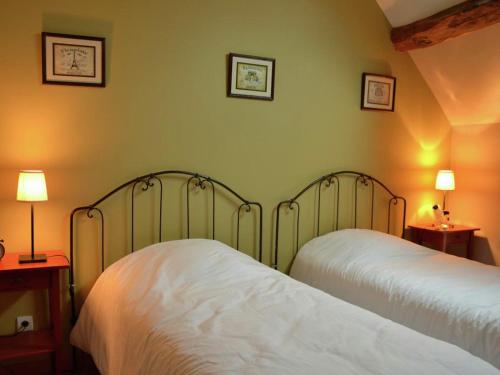 sypialnia z 2 łóżkami i 2 lampkami na ścianie w obiekcie Authentic holiday home in active surroundings near Chilleurs-aux-Bois w mieście Chilleurs-aux-Bois