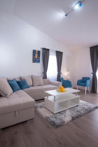 a living room with a couch and a coffee table at Apartments Grand in Sveti Stefan