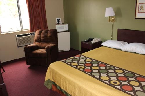 um quarto de hotel com duas camas e uma cadeira em Knights Inn Albany em Albany