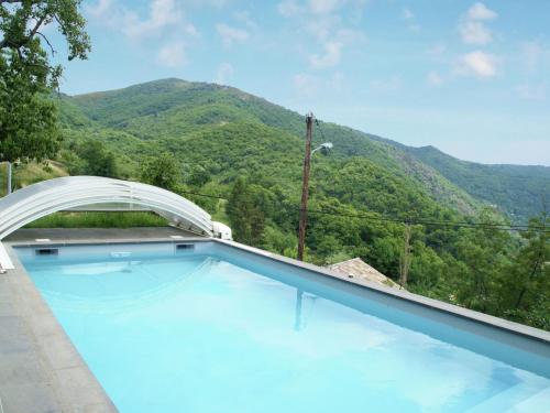 a swimming pool with a mountain in the background at Stunning detached holiday home with heatable pool in Burzet
