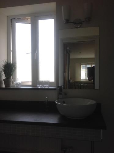 a bathroom with a sink and a mirror at Quinlan & Cooke Boutique Townhouse and QCs Seafood Restaurant in Cahersiveen