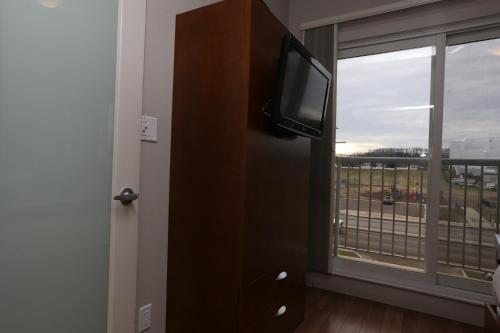 a room with a tv and a window with a view at Baymont by Wyndham Fort McMurray in Fort McMurray