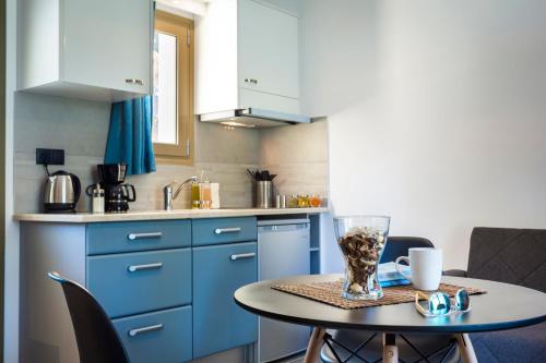 a kitchen with blue cabinets and a table with a vase on it at Cypress Garden Villas in Svoronata