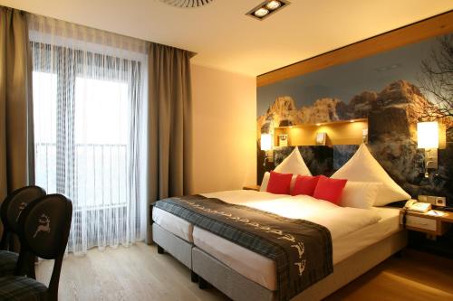 a hotel room with a large bed with red pillows at Congress Hotel am Stadtpark in Hannover