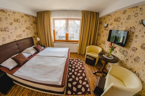 1 dormitorio con 1 cama grande y TV en Penzion Panda en Turčianske Teplice