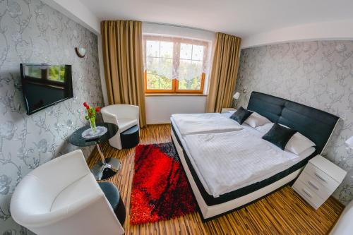 a bedroom with a large bed and a television at Penzion Panda in Turčianske Teplice