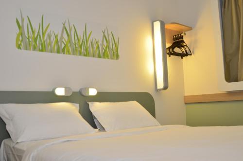 a bedroom with a bed with two white pillows at ibis budget Curitiba Aeroporto in São José dos Pinhais