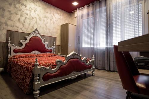 a bedroom with a red bed in a room with windows at Hotel Royal in Viverone