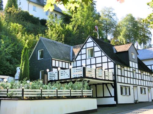 une maison en noir et blanc avec un jardin à l'avant dans l'établissement Spacious holiday home with terrace, à Schmallenberg