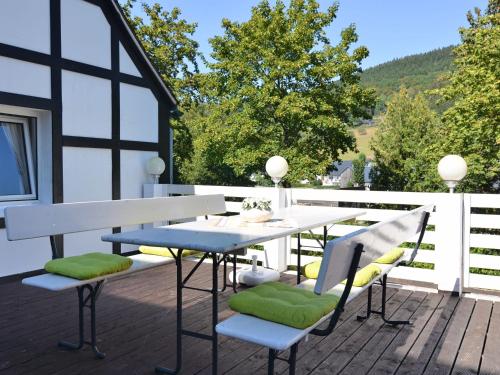 eine Terrasse mit einem Tisch und Stühlen auf einer Terrasse in der Unterkunft Spacious holiday home with terrace in Schmallenberg