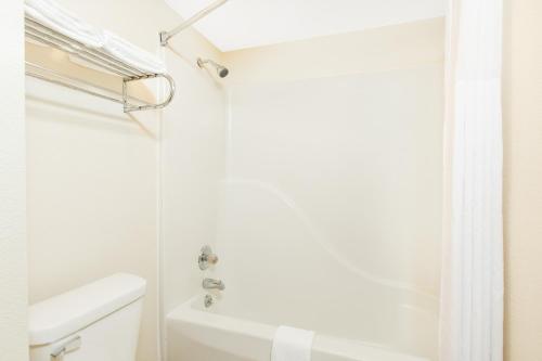 a white bathroom with a shower and a toilet at Days Inn by Wyndham Effingham in Effingham