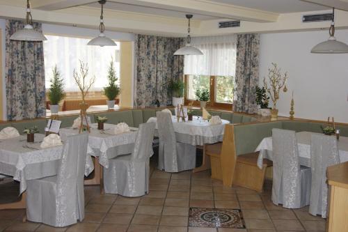 a dining room with white tables and chairs at Das Sonnenheim in Bad Kleinkirchheim