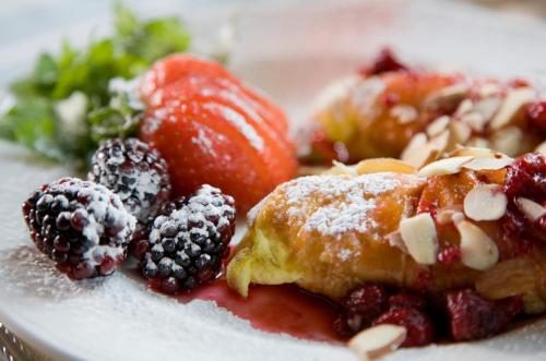 a plate of food with fruit and powdered sugar at Berry Manor Inn in Rockland