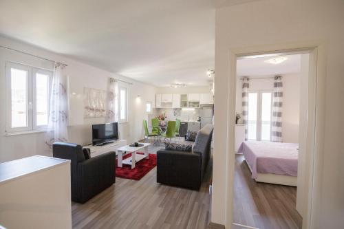 een woonkamer met een bank en een woonkamer met een bed bij Apartman Jurica in Komiža