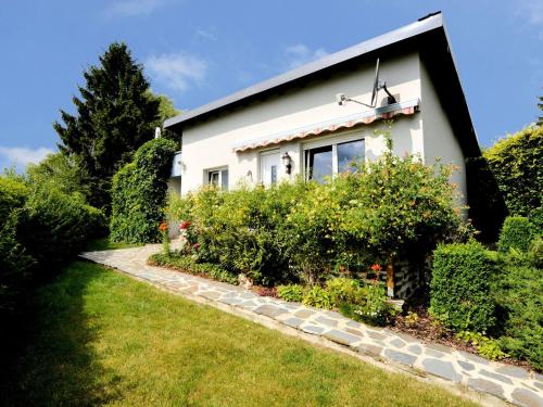 une maison blanche avec un jardin en face dans l'établissement Cozy Holiday Home in Boevange Clervaux with Garden, à Boevange-Clervaux