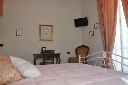 a bedroom with a bed and a desk and a window at Villa Del Poeta in Sulmona
