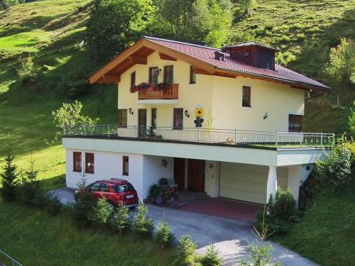 a house with a car parked in front of it at Apartment close to the ski area in Hüttschlag