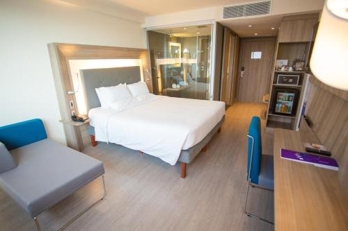 リオデジャネイロにあるNovotel RJ Porto Atlanticoのベッドと椅子付きのホテルルーム
