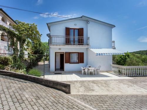 a white house with a balcony and a patio at Nice apartment on the outskirts of Silo in Šilo