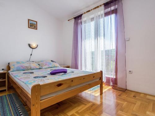 ein Schlafzimmer mit einem Bett und einem großen Fenster in der Unterkunft Apartment in Šilo near the Sea in Šilo