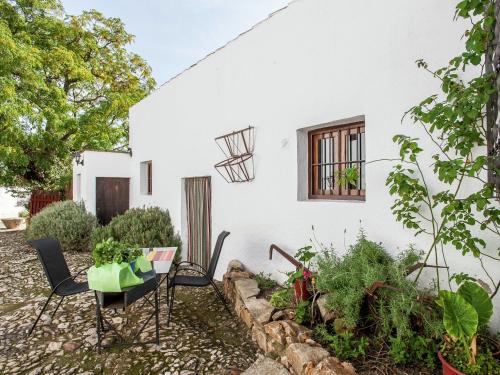 Fuentes de CesnaにあるVintage Farmhouse in Algarinejo with Terraceの庭のテーブルと椅子付きの家