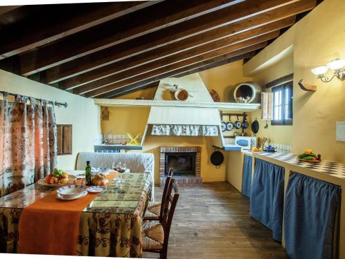 a kitchen with a long table and a fireplace at Vintage Farmhouse in Algarinejo with Terrace in Fuentes de Cesna