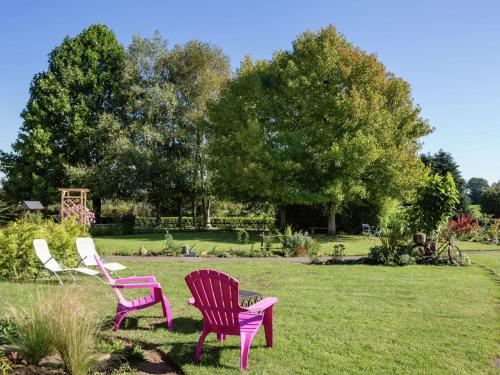 three chairs sitting in the grass in a yard at Relaxing g te with terrace near Pont Aven in Mellac