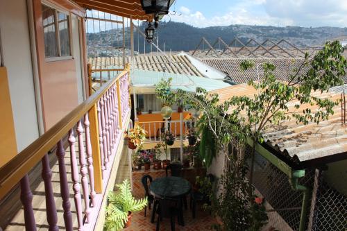 un balcón de una casa con mesa y sillas en Hostal Yumbo Imperial en Quito