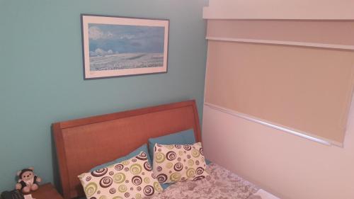 a small bedroom with a bed and a picture on the wall at Porto Real Suítes in Mangaratiba