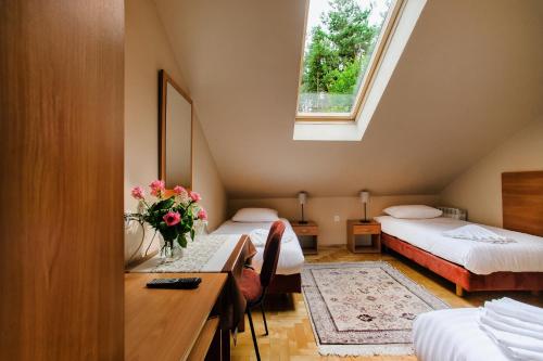 a room with two beds and a desk and a window at Hotel Galicja in Ulanów