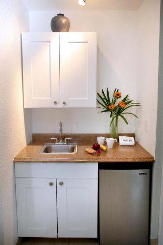 a kitchen with white cabinets and a sink at The Cabanas Guesthouse & Spa - Gay Resort catering to Gay Men in Fort Lauderdale