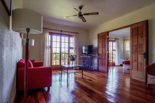 a living room with a red couch and a ceiling fan at Hotel Terraviña in Santa Cruz