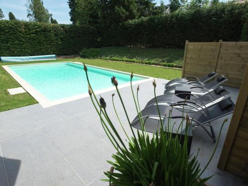a group of chairs sitting next to a swimming pool at Modern Mansion in Hasti re par Del with Pool in Hastière-par-delà