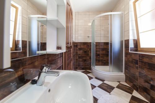 a bathroom with a sink and a shower at Guest House Rustico in Korenica