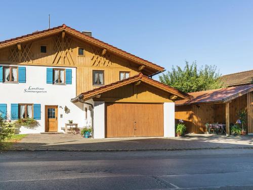 ein Haus mit einer Holzgarage und einem Gebäude in der Unterkunft Stunning apartment in Bad Bayersoien near the ski area in Bayersoien