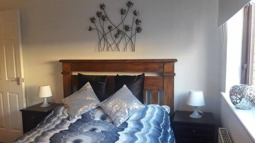 Un dormitorio con una cama con almohadas. en Sunnyside Apartments en Coatbridge