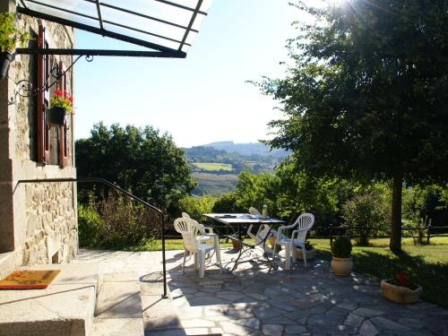 a patio with a table and chairs and a view at Comfortable holiday home with garden in Cassaniouze