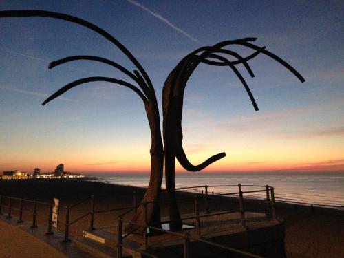 a sculpture of a palm tree on the beach at Comfort Aan Zee Guestrooms in Ostend