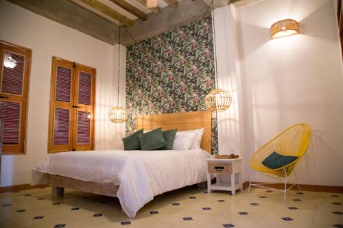 una camera da letto con un letto e una sedia gialla di Hotel Boutique Casa Mia a Santa Marta