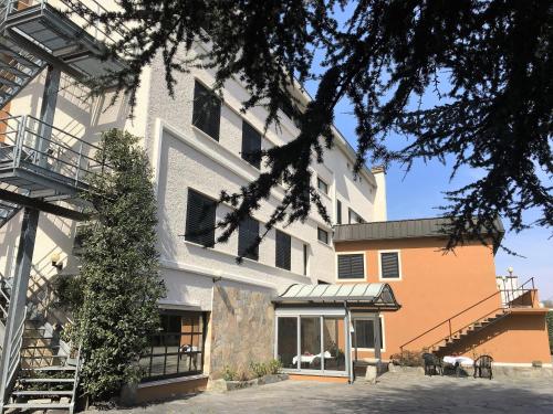 a large white building with a staircase in front of it at Hotel La Goletta in Binasco