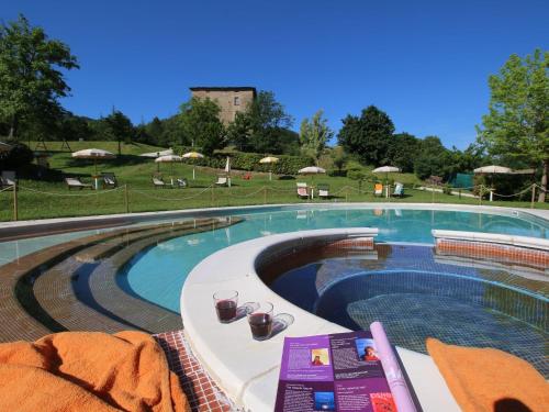 una grande piscina con sedie e ombrelloni di Belvilla by OYO Casa Ginepro ad Apecchio