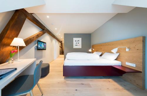 a hotel room with a bed and a desk at Hotel Die Alm in Oberkirch