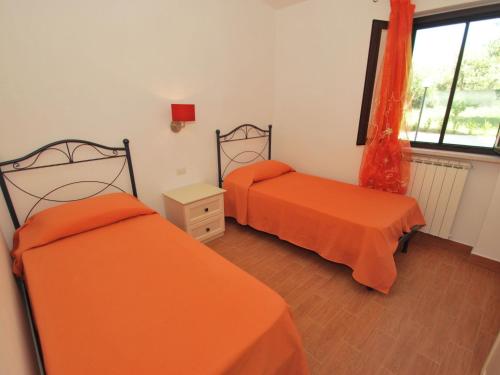 ヴィエステにあるNice apartment with AC, in beautiful national parkのオレンジのシーツが備わる客室内のベッド2台