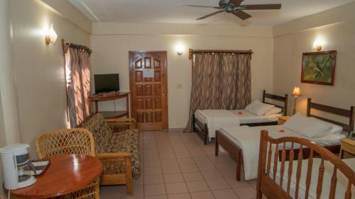 Sala de estar con sofá, cama y mesa en Black Orchid Resort, en Burrell Boom