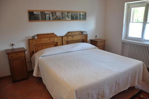 een slaapkamer met een bed, houten kasten en een raam bij Laghel7 Agritur in Arco