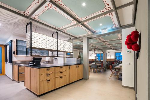 奧伯基希的住宿－迪阿爾姆酒店，一个带木制橱柜和大型天花板的厨房
