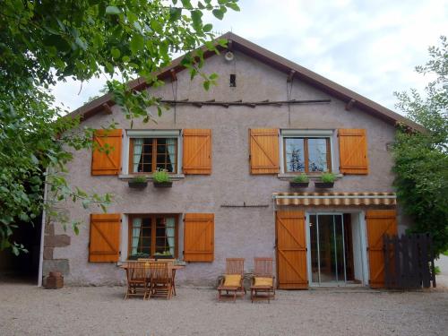 a house with chairs and tables in front of it at Holiday home near Chapelle Aux Bois in Bains-les-Bains