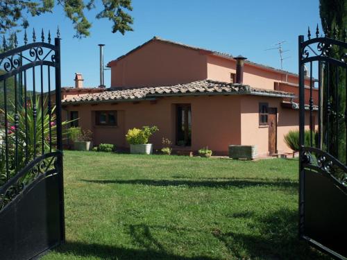 a house with a gate in front of a yard at Belvilla by OYO Quattro Orcia in Celle sul Rigo