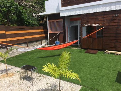 a hammock in a yard in front of a house at South Island in Itoman