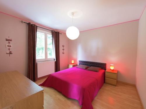 a bedroom with a pink bed and a window at Modern vacation home with private garden in Bathernay